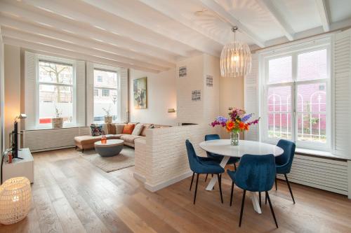a living room with a table and blue chairs at CASASdeCASPER - Apartment Alkmaar in Alkmaar