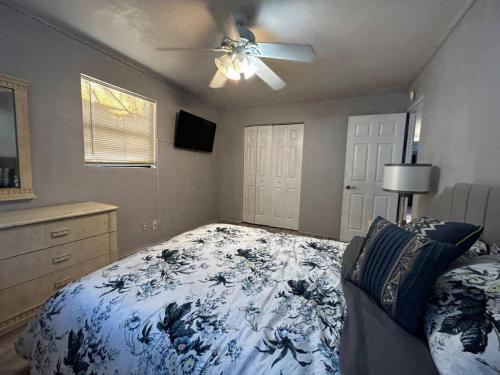 Un dormitorio con una cama y un ventilador de techo. en Beach Break House by the Surf, en Daytona Beach