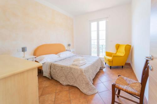 a bedroom with a bed and a yellow chair at Portico in Moneglia