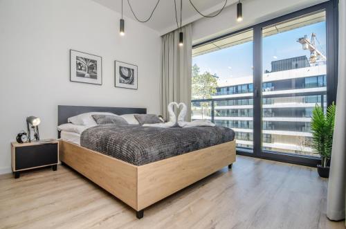 sypialnia z łóżkiem i dużym oknem w obiekcie Apartamenty Shellter Rogowo - ALL DAY HOLIDAY w Rogowie