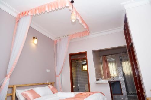 a bedroom with a canopy bed and a window at WestWay Luxury Suites in Mbarara