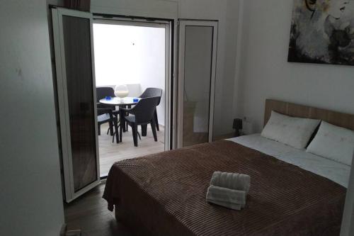 a bedroom with a bed and a table with chairs at Iliaktis Cozy & Quiet Apartment in Heraklio Town