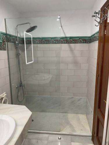 a bathroom with a glass shower with a sink at Bonito Ático en el centro de la ciudad in Sanlúcar de Barrameda