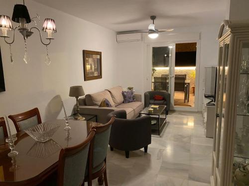 a living room with a couch and a table at Bonito Ático en el centro de la ciudad in Sanlúcar de Barrameda