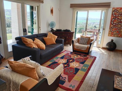 sala de estar con sofá y alfombra en Villa luce e relax en Saturnia