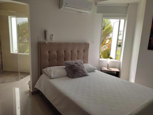 una camera con un grande letto e due finestre di Habitación Amoblada Tipo Hotel a Tuluá
