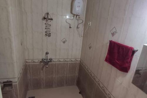 a bathroom with a shower with a red towel at Furnished Apt near Palolem Beach¶WiFi ¶Forest view in Canacona