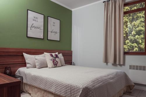 a bedroom with a bed with green walls and a window at Утро без Аларма, Смолянски езера. Alarm free Morning Smolyan lakes in Smolyan