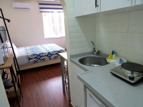 eine Küche mit einem Waschbecken und ein Bett in einem Zimmer in der Unterkunft Istanberry - Royal Apartments in Istanbul