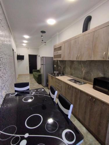 una cocina con mesa negra y sillas. en Комфортная квартира в Ванадзоре, en Vanadzor