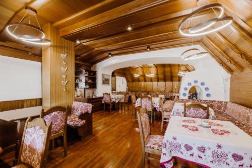 comedor con mesas y sillas y techos de madera en Hotel Rosa Wellness & SPA, en Vigo di Fassa