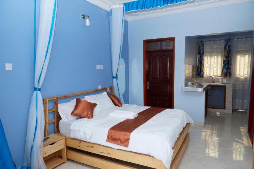 1 dormitorio con 1 cama en una habitación azul en WestWay Luxury Suites, en Mbarara