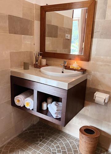 a bathroom with a sink and a mirror and towels at Dharma Shanti Villa - Private Pool - Peaceful Ubud Escape in Ubud
