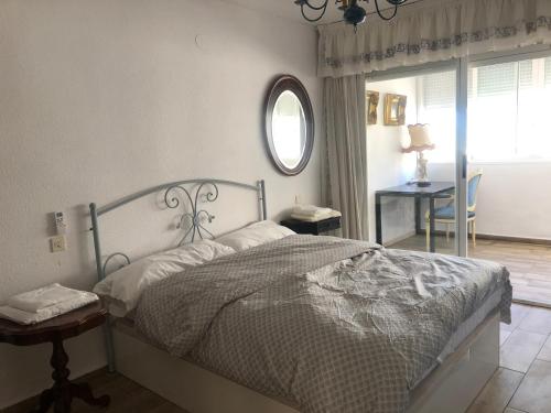 a bedroom with a bed and a table and a mirror at HOLIDAY CHALET BENIDORM in Benidorm
