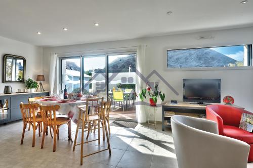 eine Küche und ein Wohnzimmer mit Tisch und Stühlen in der Unterkunft LocaLise - M11 - Ty Gwennili - Maison de plain pied avec terrain entièrement clôturé - Accès plage et centre à pied - Wifi inclus - Draps inclus - Animaux non admis in Le Guilvinec
