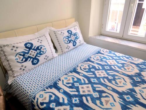 Bett mit blauer und weißer Bettwäsche und Kissen in der Unterkunft Istanberry - Royal Apartments in Istanbul