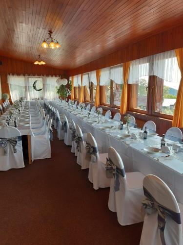 a large banquet hall with white tables and chairs at Penzion Vyhlídka Janovičky in Broumov