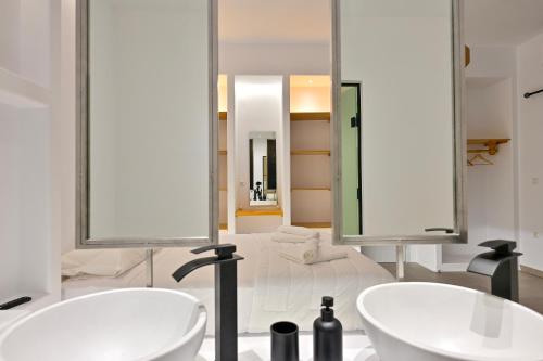 dois lavatórios numa casa de banho com dois espelhos em Oliva Naxos Apartments em Naxos Chora