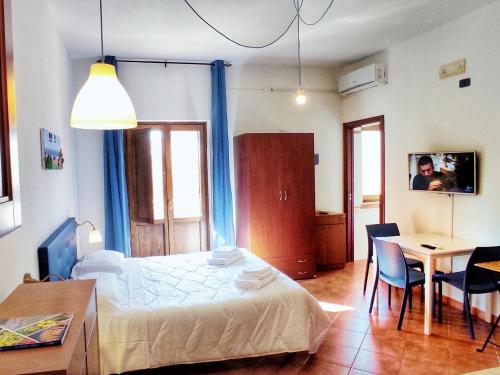 a bedroom with a bed and a table with chairs at That's Amore Cilento Country House in Agnone