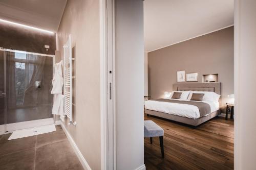 a bedroom with a bed and a bathroom with a shower at Villa Adelaide Relais & Wine in Calamandrana