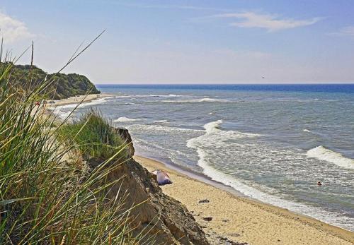 a beach with a retaining wall and the ocean at Ferienhaus Leuchtfeuer - Buchungen ab 4 Übernachtungen in Putgarten