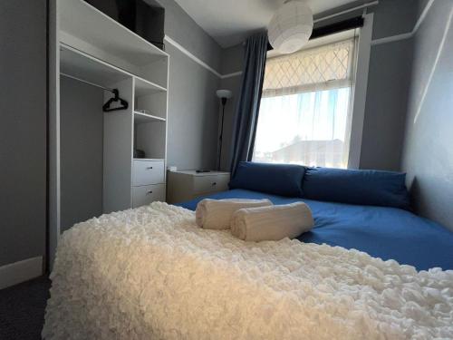 a bedroom with a blue bed with a large window at Shirley House 4, Guest House, Fully Equipped Kitchen with Fridge, Washer, Dryer, Self Catering, Self Check in, Great for Contractors, 5 min to BAT, 20 min to Fawley Refinery, close to Southampton Central, Ideal for Longer Stays in Southampton