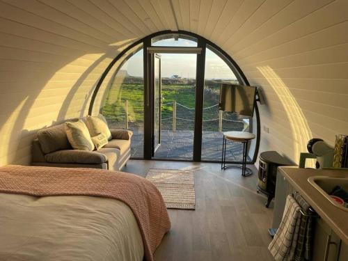 um quarto com uma cama e um quarto com uma janela em Gaoth na Mara pod em Doolin