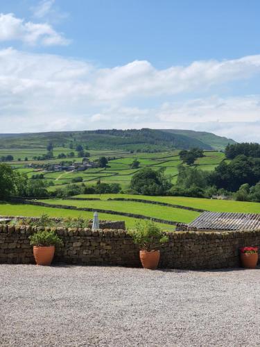 a stone wall with potted plants on top of it at Howgill farm Bolton Abbey in Appletreewick