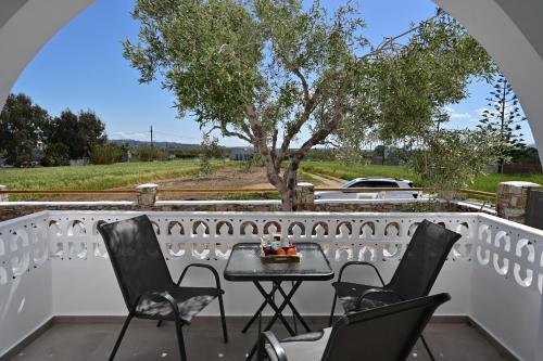 a table and chairs on a balcony with a tree at Oliva Naxos Apartments in Naxos Chora