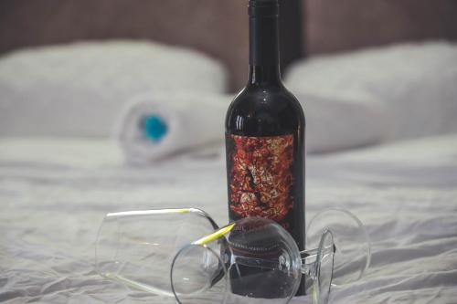 a bottle of wine and glasses on a bed at Mandala in Mount מנדלה בחרמון סוויטה in Majdal Shams