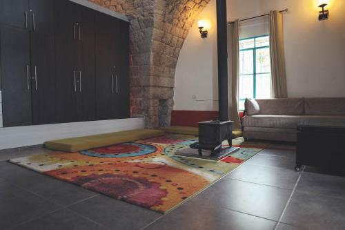 a living room with a fireplace and a rug on the floor at Mandala in Mount מנדלה בחרמון סוויטה in Majdal Shams