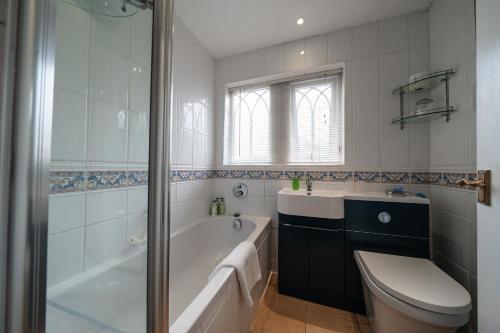 y baño con bañera, aseo y lavamanos. en The Salty Monk Bed & Breakfast, en Sidmouth