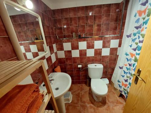 a small bathroom with a toilet and a sink at apartamento Cambrils casco antiguo in Cambrils