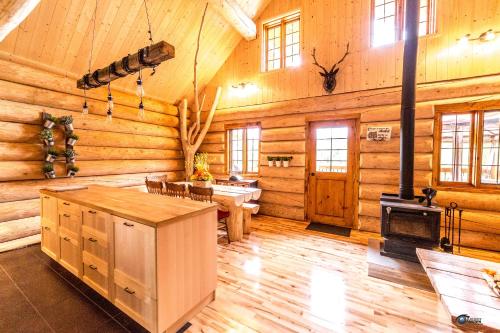 Habitación grande con estufa en una cabaña de madera. en Chalet bois rond aux paysages uniques avec Spa !, en Lac-aux-Sables