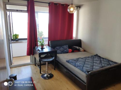 Habitación pequeña con cama y escritorio. en Midt Town Apartment Room en Aarhus
