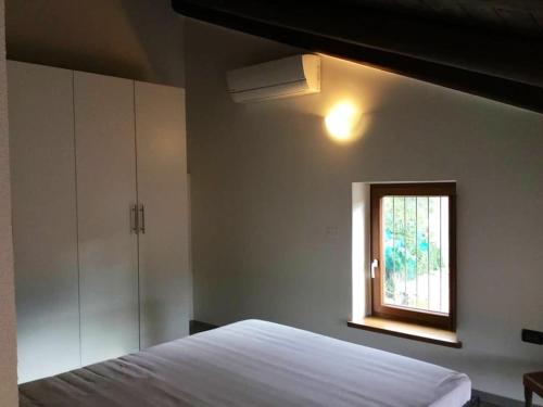 ein Schlafzimmer mit einem weißen Bett und einem Fenster in der Unterkunft Casa Torre con terrazza panoramica in Futani