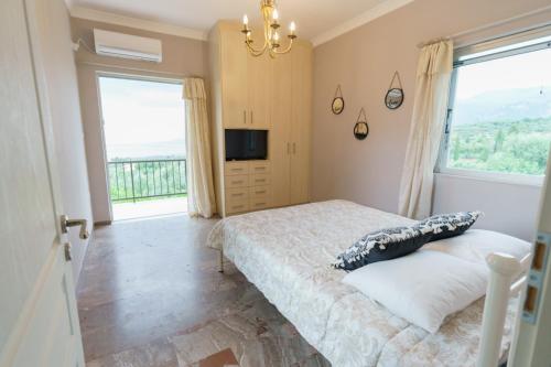 een slaapkamer met een bed en een groot raam bij Tsigkos Apartment ! in Áno Dholoí