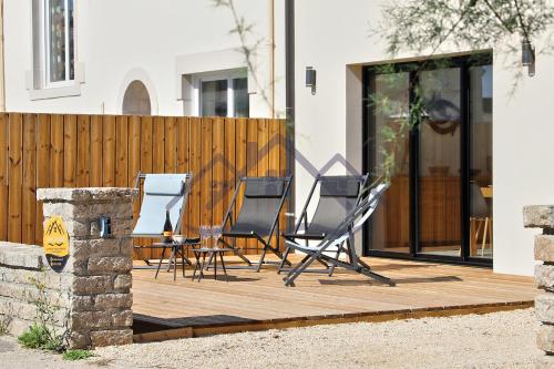 eine Sitzgruppe auf einer Holzterrasse in der Unterkunft LocaLise - M68 - An Aod Melen - Maison neuve à 50m de la plage et à quelques pas du centre et des plages - Draps inclus - Wifi inclus in Le Guilvinec