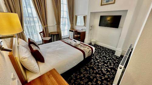 a hotel room with a bed and a desk at Andorra Guest Accommodation in Brighton & Hove