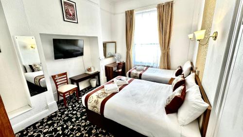a hotel room with two beds and a window at Andorra Guest Accommodation in Brighton & Hove