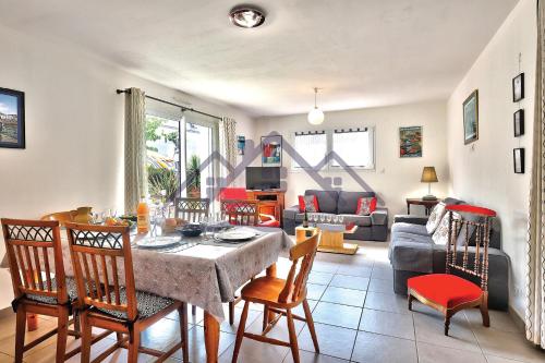 un salon avec une table et des chaises de salle à manger dans l'établissement LocaLise - M8B - Ty Katell-Roz - Maison de plain-pied avec un terrain entièrement clos à quelques pas de la plage et du centre - Wifi inclus - Draps inclus - Animaux bienvenus, à Tréffiagat