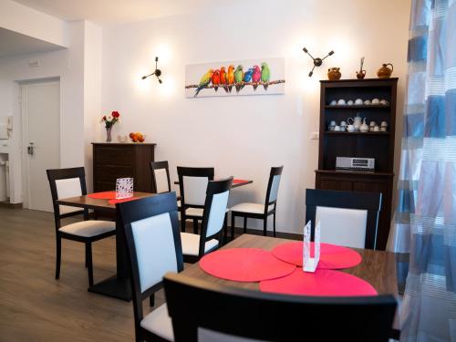une salle à manger avec des tables, des chaises et des assiettes rouges dans l'établissement Anastasio Vatican Rooms G H, à Rome