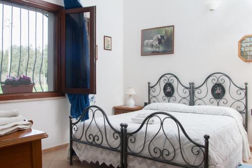 een slaapkamer met een bed en een raam bij Il Vecchioliveto di Ornella in Marrùbiu