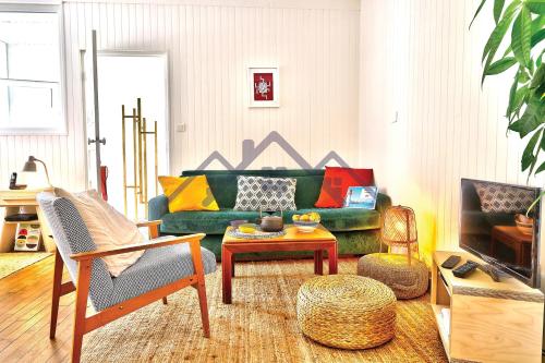 - un salon avec un canapé vert et une table dans l'établissement LocaLise - M20 - La maison des Dunes à 2 pas du centre - Tout à pied, plage, port, centre, commerces marché - Wifi inclus - Linge de lit inclus - Animaux bienvenus, au Guilvinec