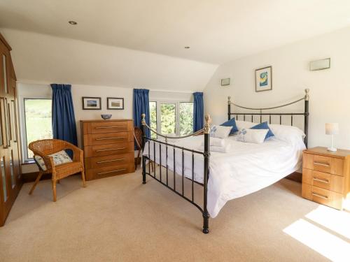 a bedroom with a large bed and a chair at Minffordd in Llangollen