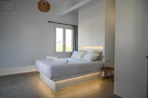 uma cama branca num quarto com uma janela em Oliva Naxos Apartments em Naxos Chora