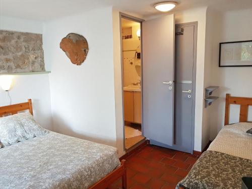 a bedroom with two beds and a door to a bathroom at Un cadre magnifique, au cœur du Verdon in Castellane
