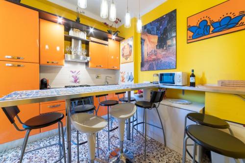 eine Küche mit orangefarbenen Schränken und Barhockern in der Unterkunft Pisa Happy House in Pisa