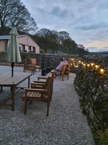 a person sitting on a bench near a stone wall at Howgill farm Bolton Abbey in Appletreewick