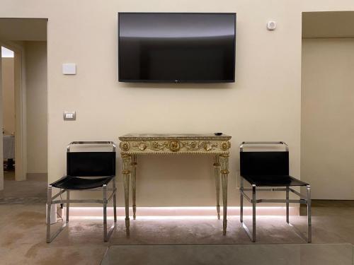 un tavolo con due sedie e una televisione su una parete di Suite di Bianca a Foligno